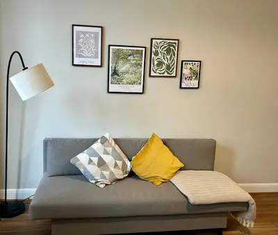 a living room with a couch with four pictures on the wall at West Dunbartonshire Flat, near Loch Lomond in Dumbarton
