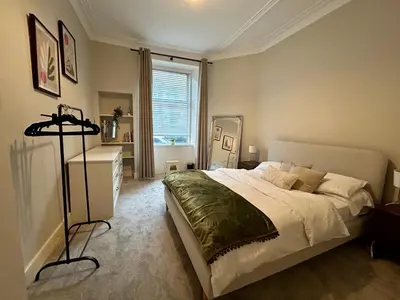 a bedroom with a large bed and a window at West Dunbartonshire Flat, near Loch Lomond in Dumbarton