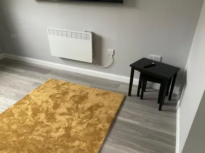 a room with a heater and a table and a rug at Largs Seaside Loft 2 R in Largs