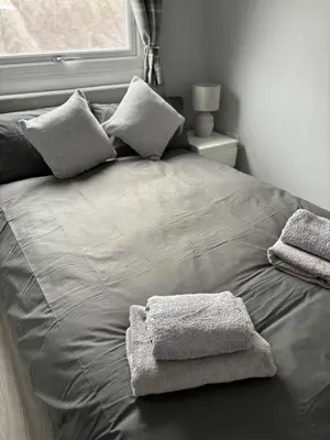 a bed with two towels on it with a window at Largs Seaside Loft 2 R in Largs