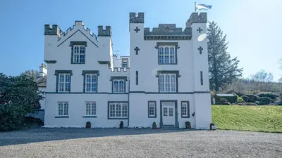 a large white castle with a flag on it at Beautiful House With Gardens Close To River Tay in Remony