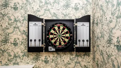 a dart board on a wall with a wallpaper at Beautiful House With Gardens Close To River Tay in Remony
