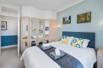 a bedroom with a large white bed with towels on it at Oban Bay Views - Fireplace, Games & Books in Oban