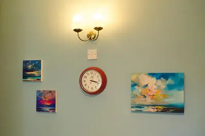 a clock on a wall with pictures on it at Oban Bay Views - Fireplace, Games & Books in Oban