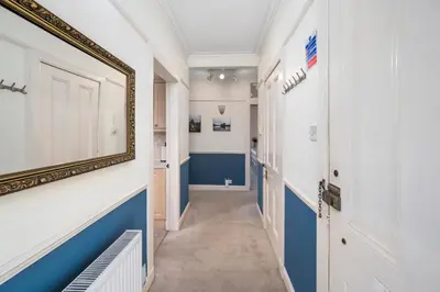 a hallway with blue and white walls and a mirror at Oban Bay Views - Fireplace, Games & Books in Oban