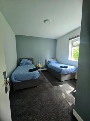 a bedroom with two beds and a window at Cunninghame 4 in Beith
