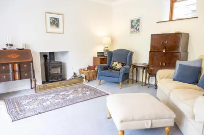 a living room with a couch and a stove at The Coach House in Saint Fillans
