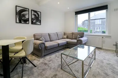 a living room with a couch and a table at Marchfield Promenade View in Prestwick