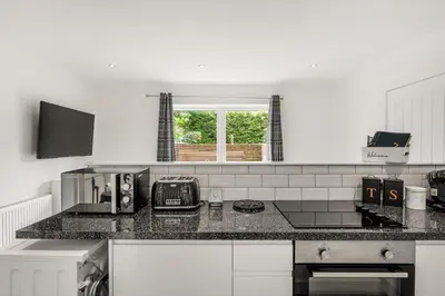 a kitchen with a black counter top and a window at Beautiful 1 BR apt with private patio and free parking in Dunollie
