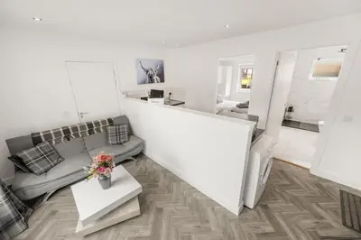 a white living room with a couch and a table at Beautiful 1 BR apt with private patio and free parking in Dunollie