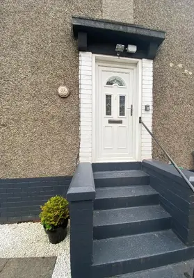 a white door with stairs in front of a building at Glasgow Apartment close to the airport in Renfrew