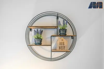 a round mirror with three potted plants on a wall at Albert Road in Gourock