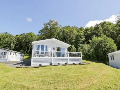 a white tiny house on a grassy field at Bethany's Retreat in Wemyss Bay