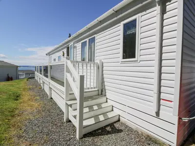 a white house with stairs on the side of it at Bethany's Retreat in Wemyss Bay