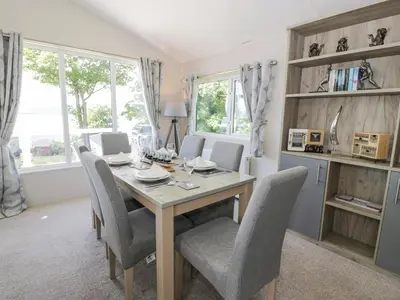 a dining room with a wooden table and chairs at Olivia's Haven in Wemyss Bay