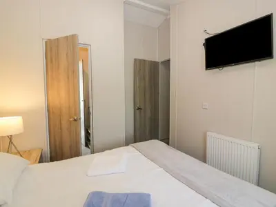 a bedroom with a bed and a flat screen tv at Olivia's Haven in Wemyss Bay