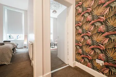 a hallway with a wall with a floral wallpaper at 4 Beds - City Gateway Getaway with Free Parking in Glasgow