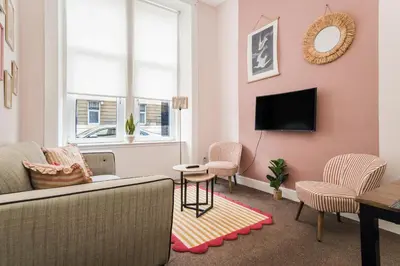 a living room with a couch and chairs and a tv at 4 Beds - City Gateway Getaway with Free Parking in Glasgow