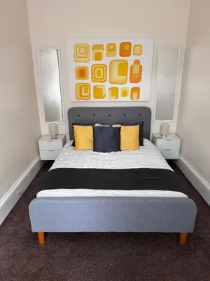 a bedroom with a large bed with yellow pillows at Heart of Oban in Oban