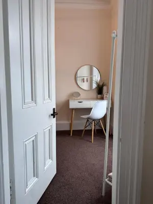 a door leading into a room with a desk and a mirror at Heart of Oban in Oban