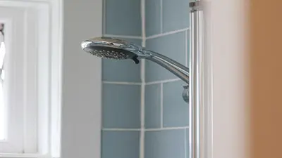 a shower head in the corner of a bathroom at Modern And Cozy Apex Apartment in Helensburgh