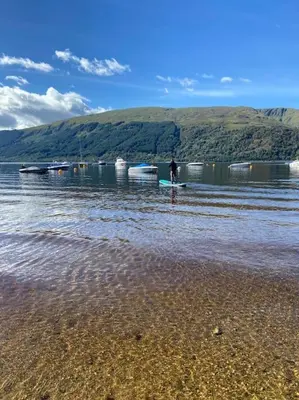 a person standing on the shore of a body of water at Lomond View Lodge in Glasgow