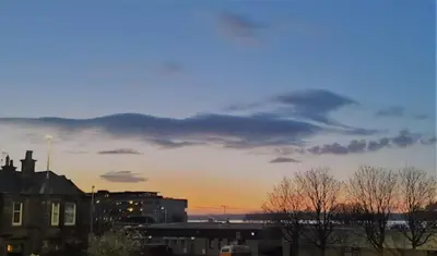 a sunset over a city with buildings and trees at Comfortable Double Room, Great Transport to City Centre and Airport, 5 mins to Beach, Great Value in Edinburgh
