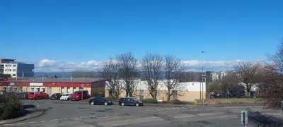 a parking lot with cars parked in front of a building at Comfortable Double Room, Great Transport to City Centre and Airport, 5 mins to Beach, Great Value in Edinburgh