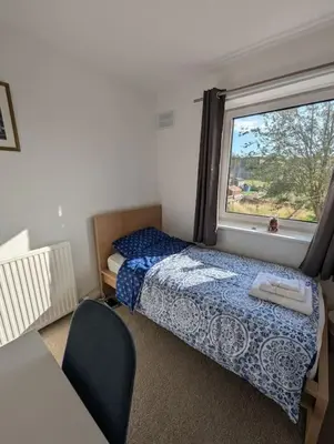 a small bedroom with a bed and a window at Lovely 3-Bed Edinburgh Flat in Edinburgh