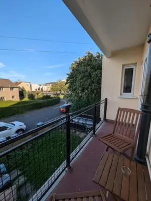 a balcony with a wooden bench and a view of a street at Lovely 3-Bed Edinburgh Flat in Edinburgh