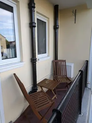two chairs sitting on a porch with a fireplace at Lovely 3-Bed Edinburgh Flat in Edinburgh