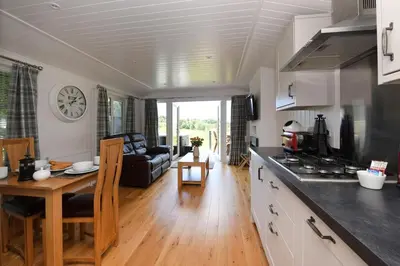 a kitchen and living room with a table and a couch at Argyll View in Langbank