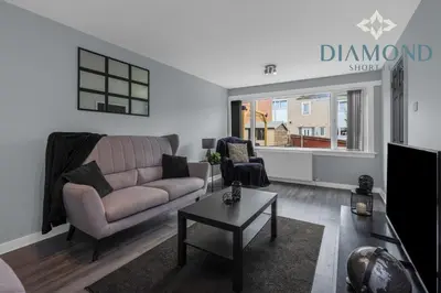 a living room with a couch and a table at Brand New 4 Bedroom House - Sleeps 4 Fully Equipped, Free Parking, WiFi, Perfect for CONTRACTORS by Diamond Short Lets in Rosyth