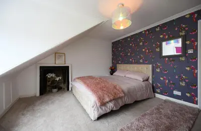 a bedroom with a bed and a staircase at Ayrbados - 4 bed townhouse in Ayr in Ayr