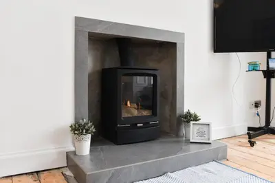 a fireplace in a living room with a stone insert at Ayrbados - 4 bed townhouse in Ayr in Ayr