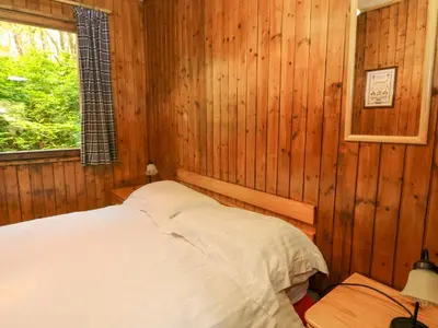 a bedroom with a bed in a wooden room at Lodge 3 - 