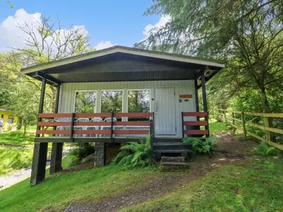 a small shed with a bench in the grass at Lodge 6 - 