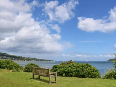 a bench sitting on the grass near the water at Lodge 4 - 