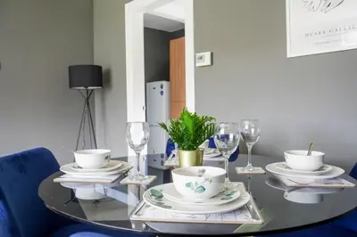 a dining room table with plates and wine glasses at Andrew House in Bathgate