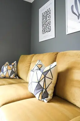 a brown couch with two pillows on it at Andrew House in Bathgate