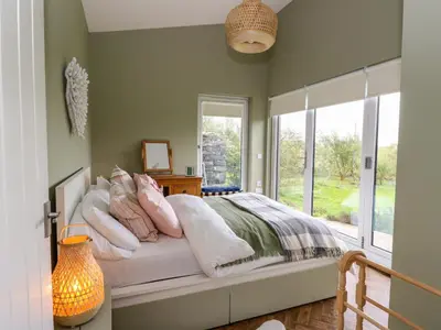 a bedroom with a bed with pillows and a window at Tirlaggan House in Oban