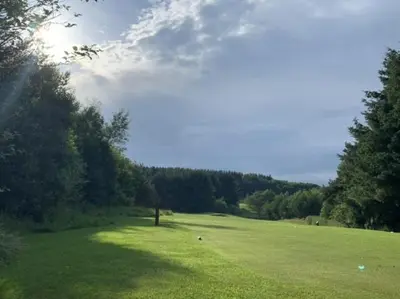 a large green field with trees in the background at Knightsridge House in Livingston