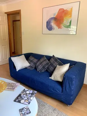 a blue couch sitting in a living room at Knightsridge House in Livingston