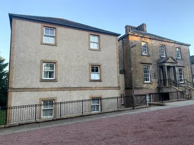 a large brick building with a fence in front of it at Knightsridge House in Livingston