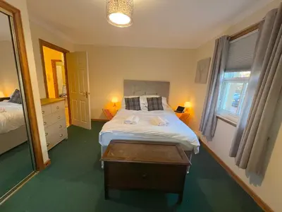 a bedroom with a bed and a table in it at Knightsridge House in Livingston