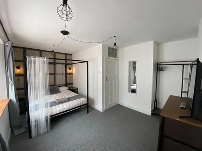 a bedroom with a bed and a dresser and a television at Shore Cottage in Girvan