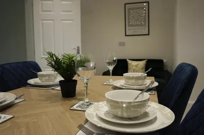 a dining room table with plates and wine glasses at Rhyber Avenue in Lanark