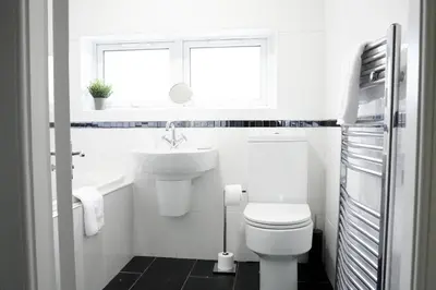 a white bathroom with a sink and a toilet at Rhyber Avenue in Lanark
