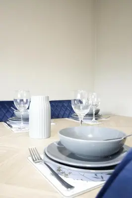 a table with a plate and wine glasses on it at Barclay House in Livingston