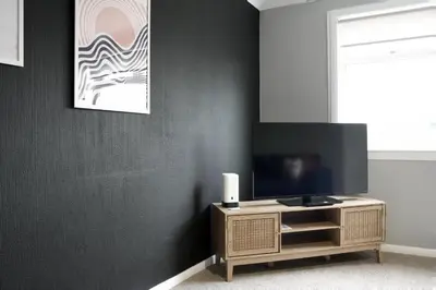 a living room with a tv on a wooden cabinet at Barclay House in Livingston